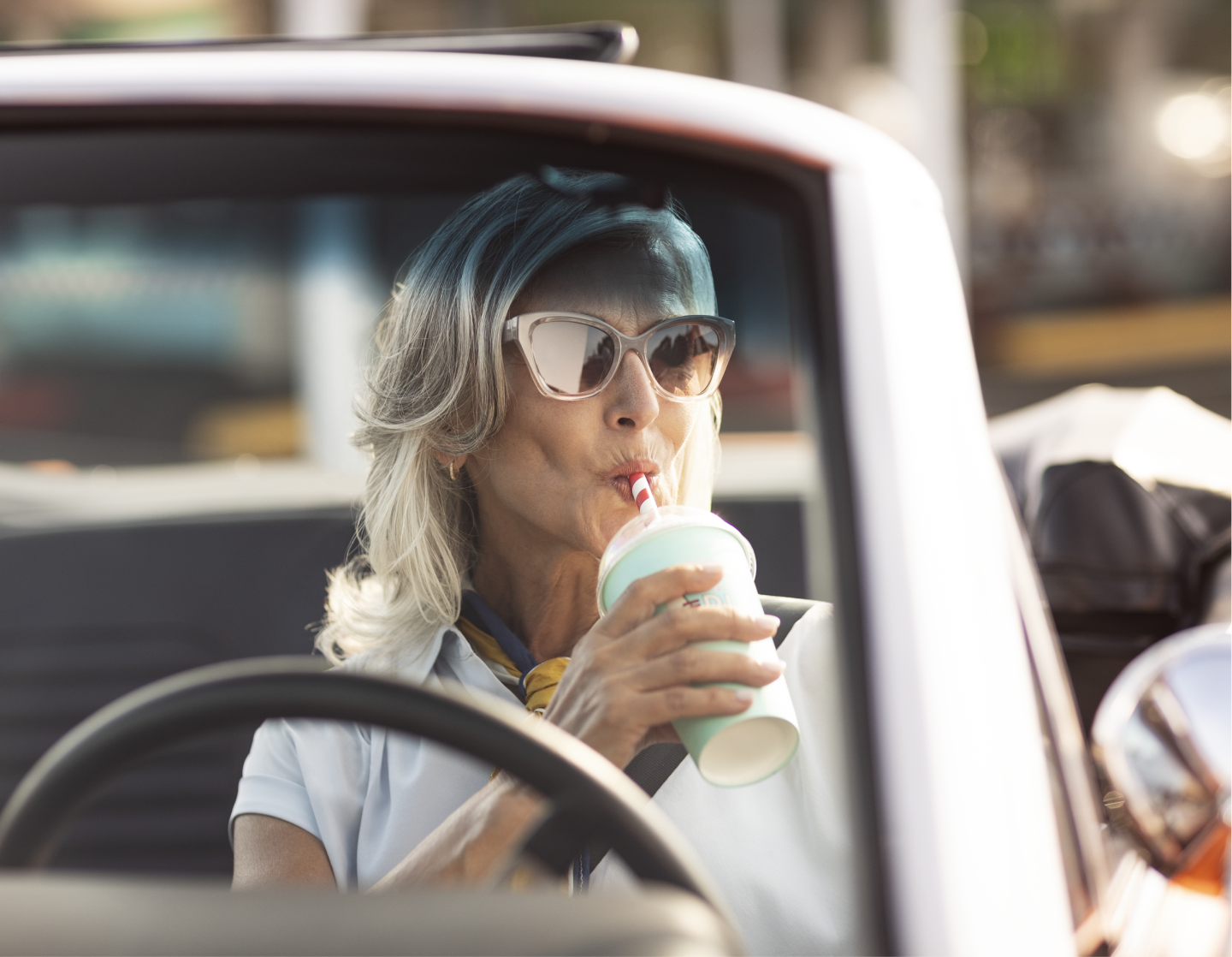 Woman drinking milkshake in car