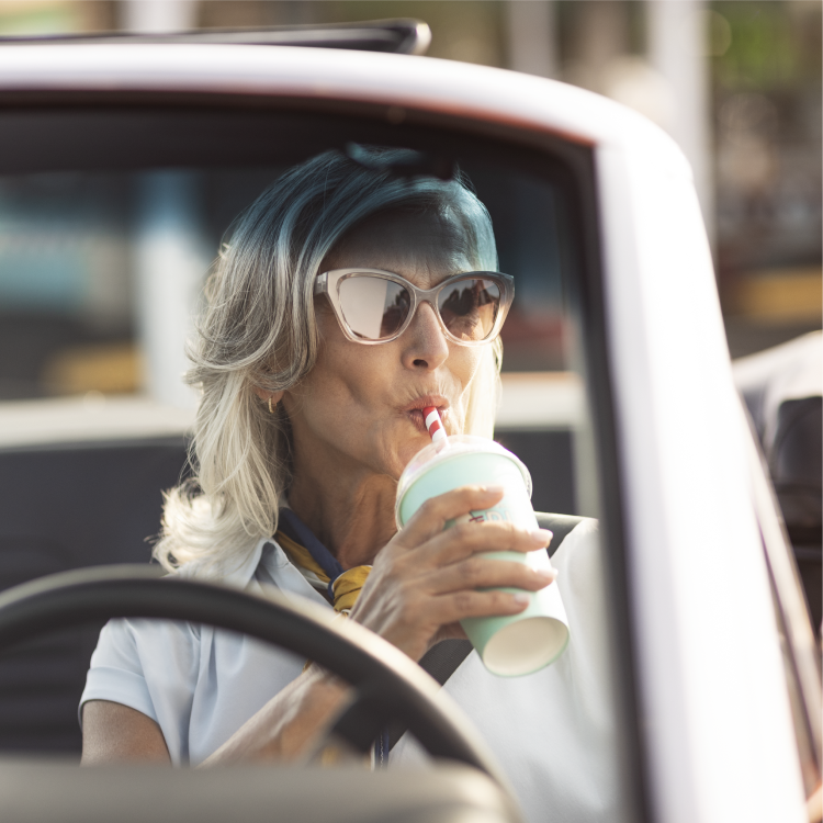 Woman drinking milkshake in car