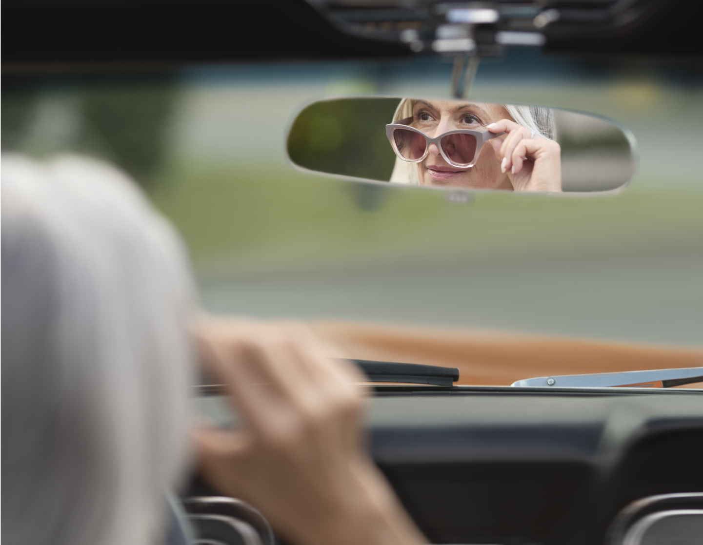 Woman looking into side view mirror