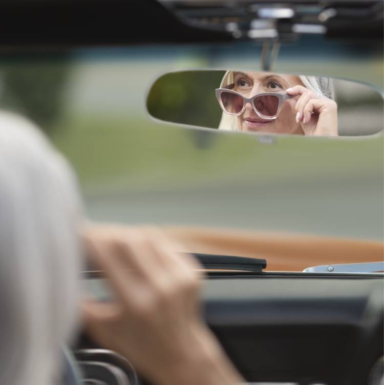 Woman looking into side view mirror