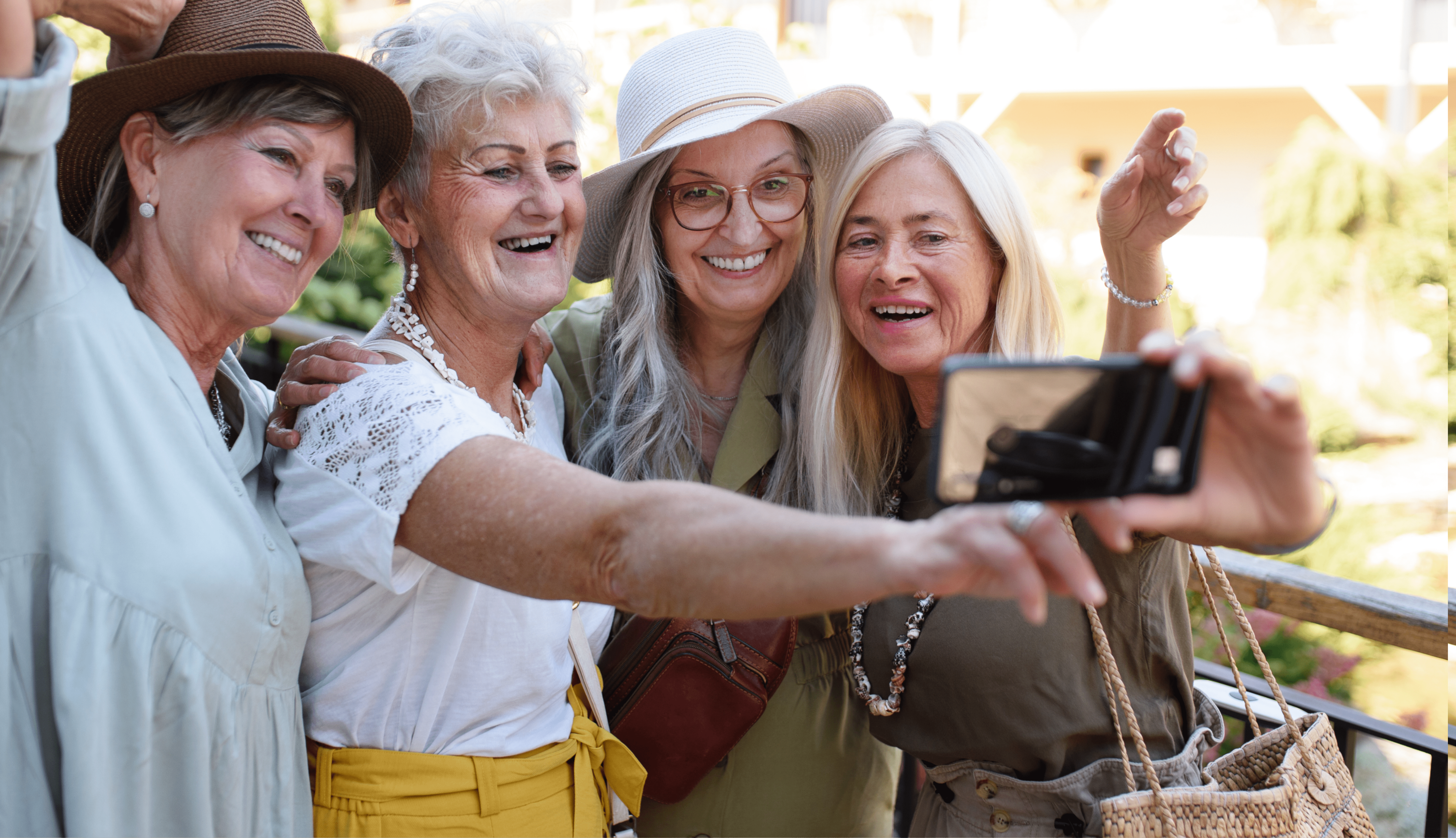 Four women taking a selfie and smiling together.